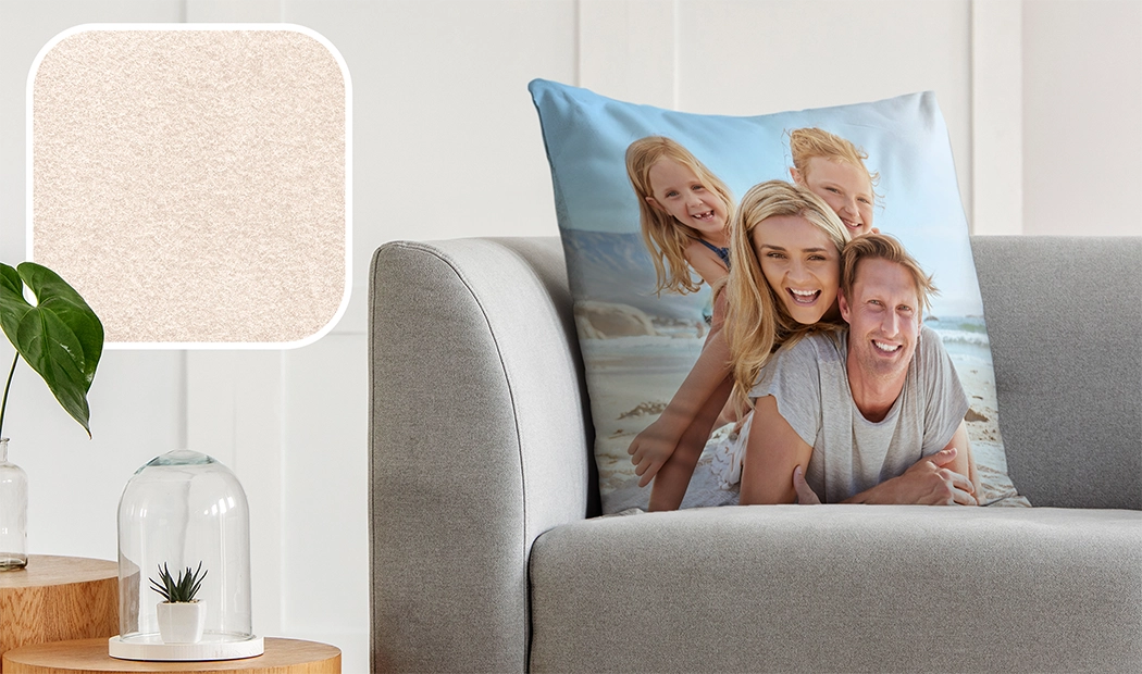 Personalisiertes Kissen mit einer glücklichen Familie auf einem grünen Samtsofa in Deutschland.