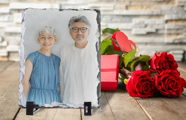 Personalised slate photo of a smiling couple in Germany, a thoughtful gift presented with red roses and gifts.