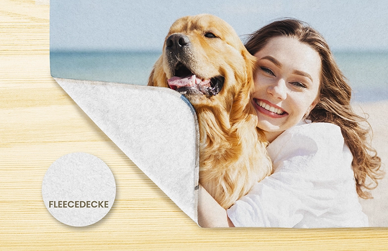Personalized fleece blanket in Germany; shows a woman hugging her golden retriever at the beach.